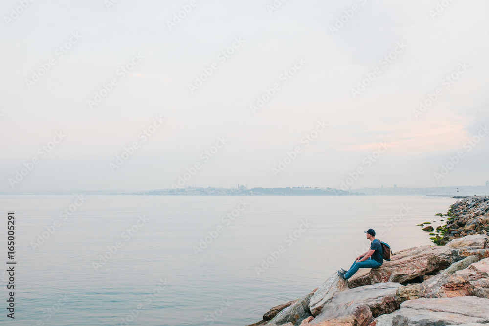 A tourist with a backpack on the coast. Travel, tourism, recreation.