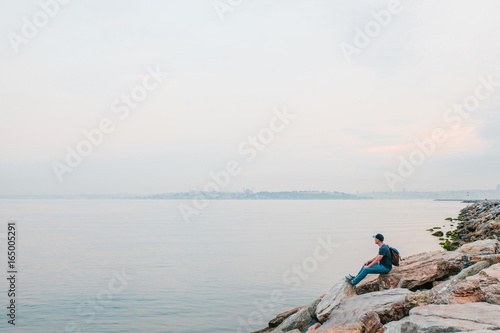 A tourist with a backpack on the coast. Travel, tourism, recreation.