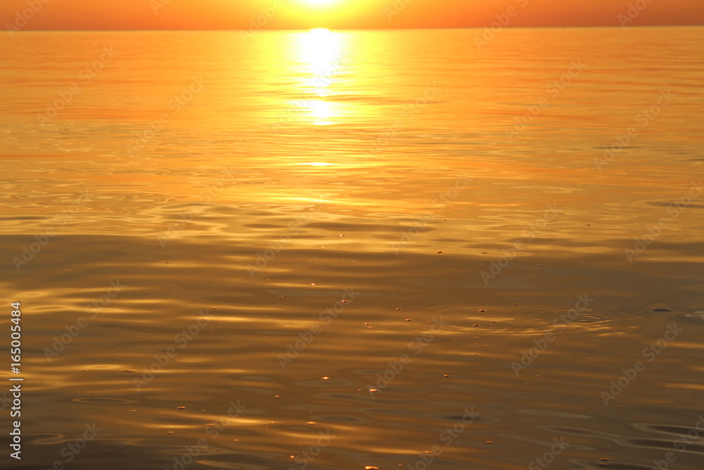 Golden water in the sea at sunset