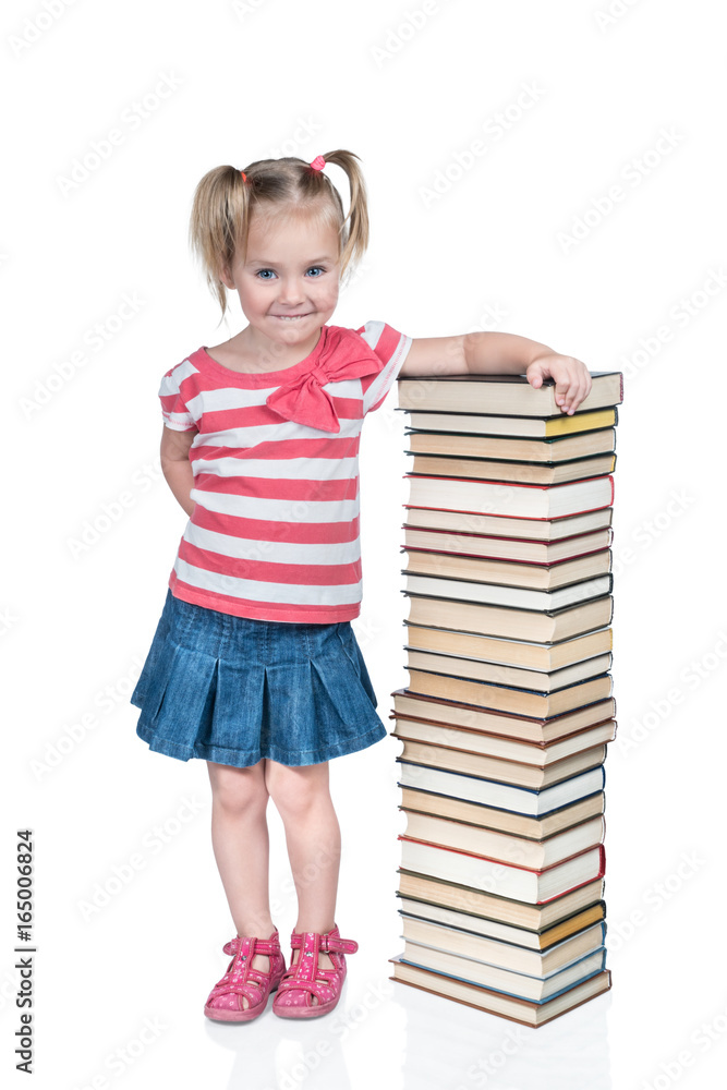 Little beautiful girl smiles slyly leaning on a high stack of books isolated on white background Little beautiful girl smiles slyly leaning on a high stack of books isolated on white background