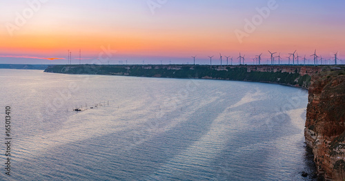 Sunset on cape Kaliakra with windmills farm  huge cliffs on black sea coast in Bulgaria