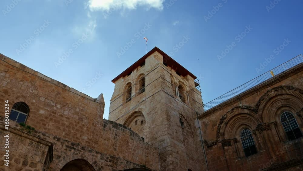 Roof of the Holy Sepulcher Church in Jerusalem with flying flag. The Holy Sepulchre Church and Empty Tomb the most sacred places for all religious Christians in the world. Calvary also located there. Roof of the Holy Sepulcher Church in Jerusalem with flying flag. The Holy Sepulchre Church and Empty Tomb the most sacred places for all religious Christians in the world. Calvary also located there.