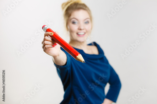 Happy woman holding giving big pencil