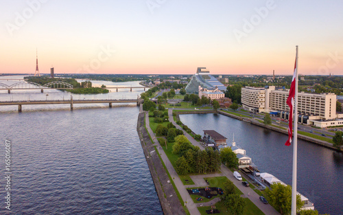 Beautiful aerial sunset view over Riga in Latvia with Huge Latvian flag in the foreground and river Daugava around the damb. photo