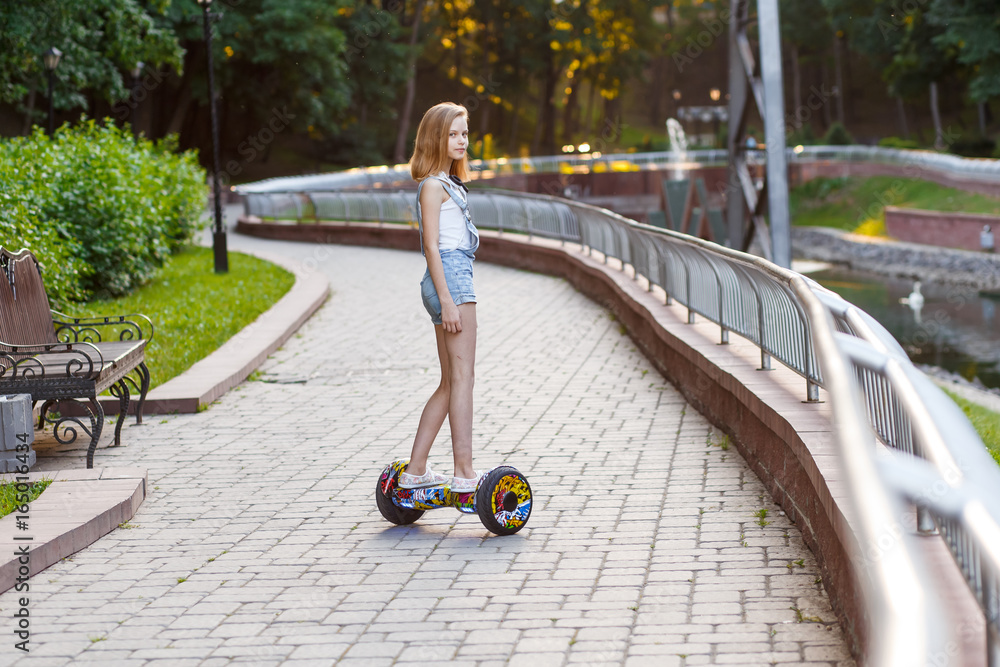 Ταπετσαρία Happy girls riding on hover boards or gyroscooters outdoors at sunset in summer