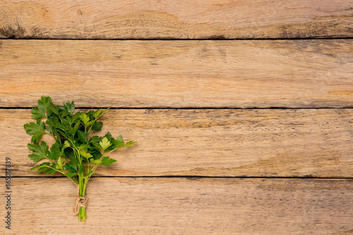 Bunch of fresh Italian Parsley tied with string on rustic wooden background