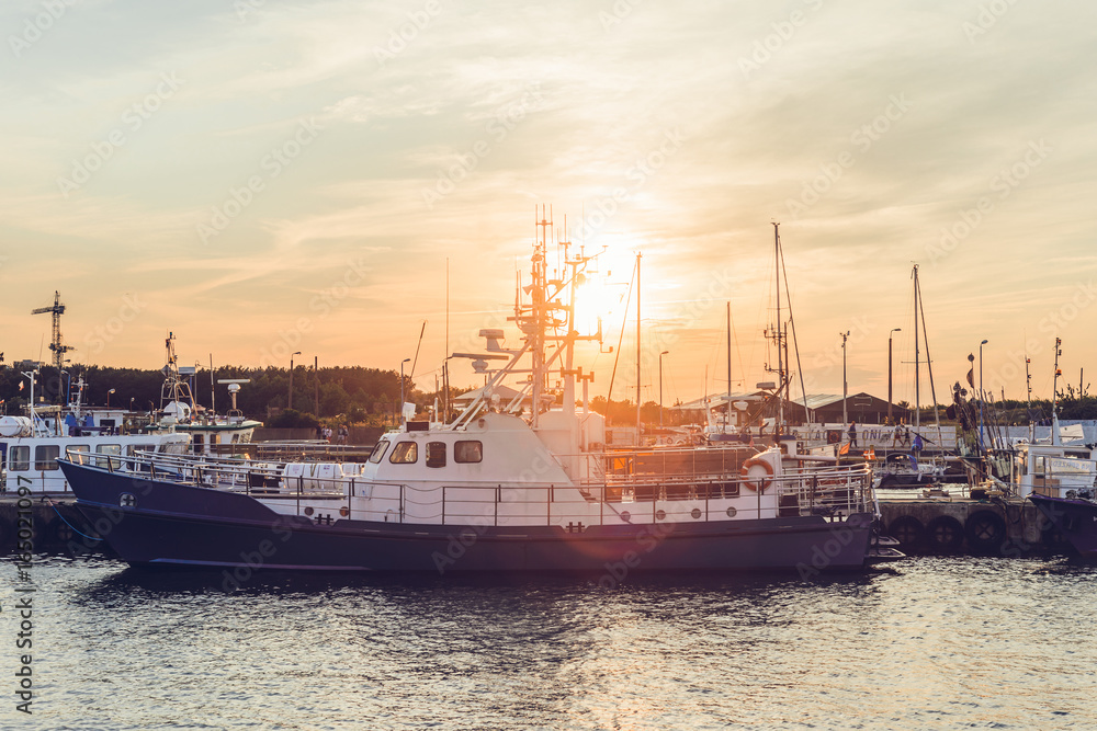 Naklejka premium Widok na zachód słońca nad łodzie w port
