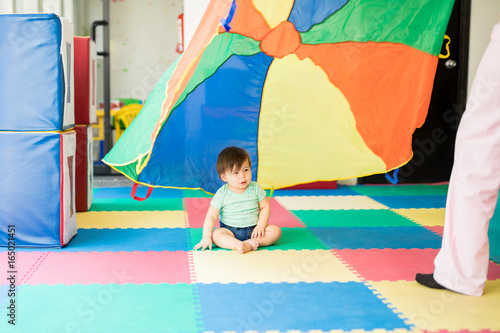 Baby looking at a colorful parachute