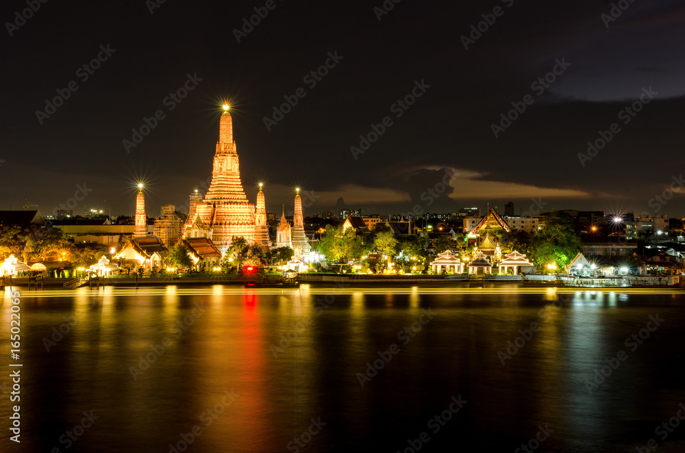 The Temple of Dawn in Bangkok, Thailand. Wat Arun, on Chao Phraya river and a beautiful night sky in Bangkok, Thailand.