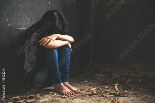 Trapped woman. Teenager with depression sitting alone in dark room
