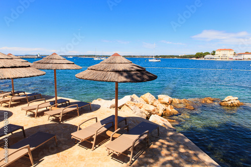 Fototapeta Naklejka Na Ścianę i Meble -  Beach umbrellas in Saint Nicholas island in Porec, Istria. Croatia