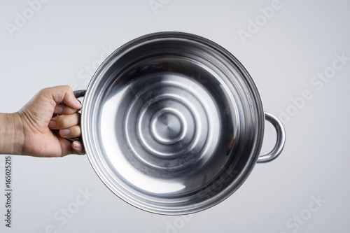 Hand holding stainless steel pan or wide pot