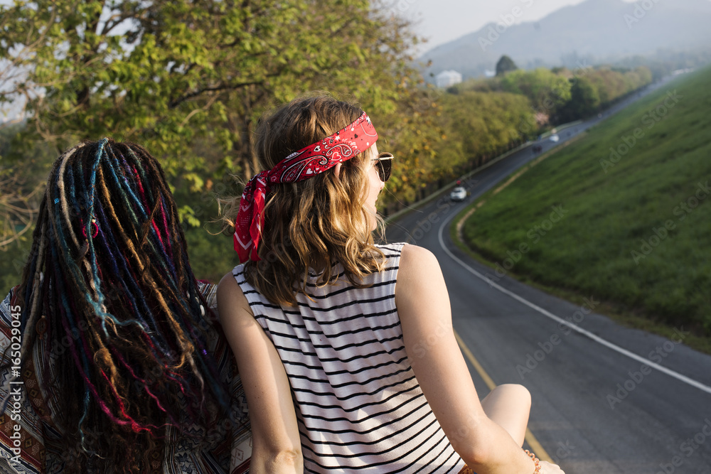 Women Friends Sitting on The Roof of the Van Traveling Road Trip Women Friends Sitting on The Roof of the Van Traveling Road Trip