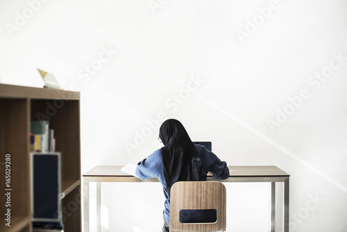 Canvas Print Islamic girl sitting and using laptop