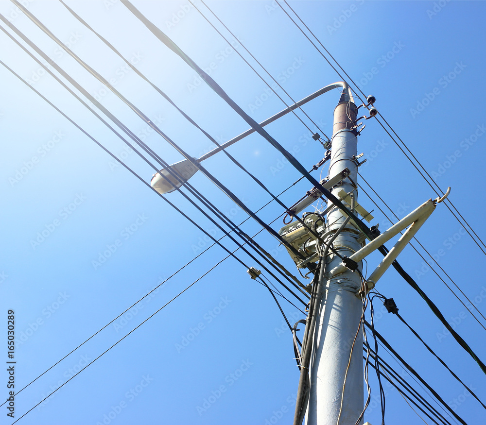 Transmission power tower electricity pylon over blue sky. Steel lattice tower used to support an overhead power line Transmission power tower electricity pylon over blue sky. Steel lattice tower used to support an overhead power line