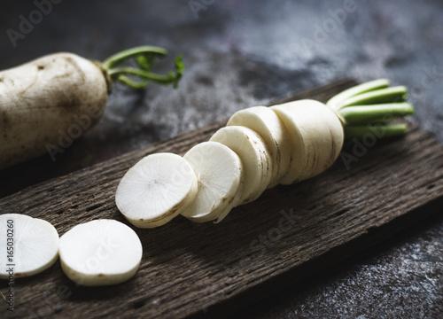 Closeup of cut daikon radish on wooden cutboard photo