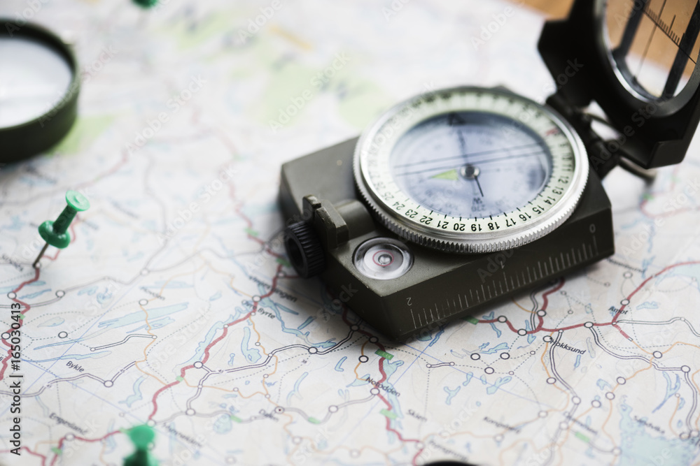 Closeup of compass on the map journey planning Closeup of compass on the map journey planning