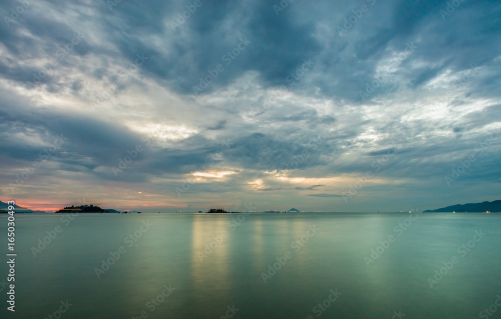 Nha Trang Vietnam sunrise with a cloudy grey sky over a turquoise ocean long exposure.