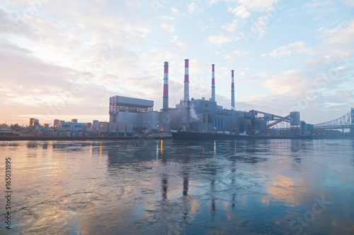 New York city infrastructure on the shore of East River at dawn. Electric Power plant before sunrise on a foggy morning.