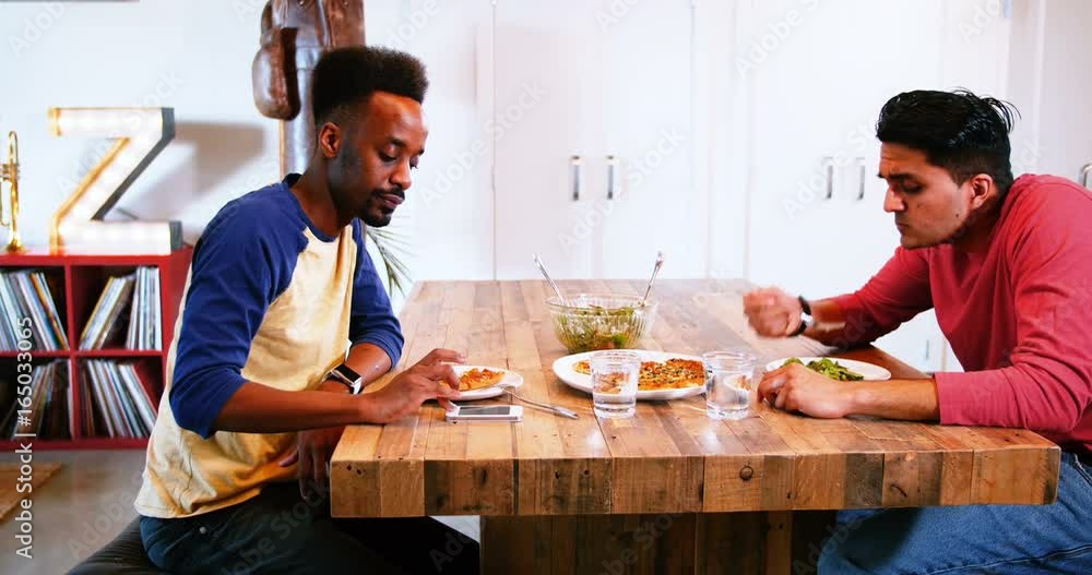 Gay couple interacting with each other while having meal Gay couple interacting with each other while having meal