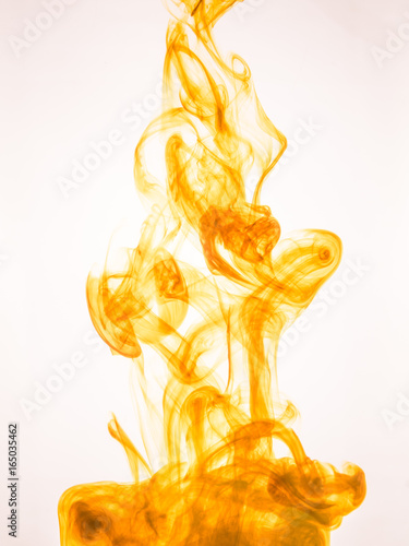 Ink swirl in a water on white background. The paint splash in the water. Soft dissemination a droplets of colored ink in water close-up. Abstract background. Explosion of color splashes acrylic ink.