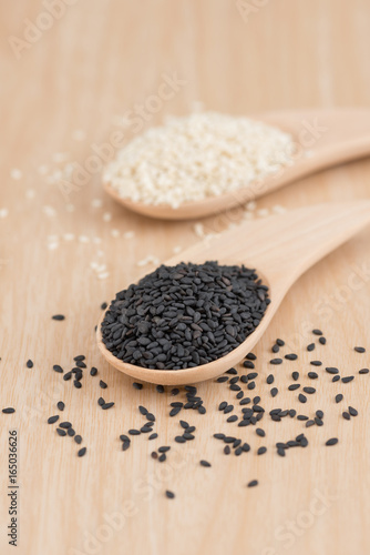 White sesame and black sesame seed on wooden spoon