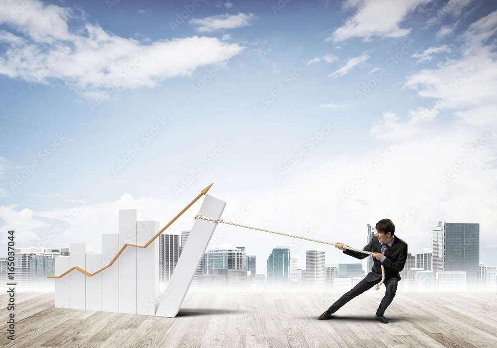 Obraz premium Man pulling with effort big pulling rope graph, as a symbol of financial growth