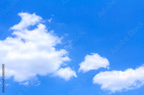 Blue sky background with white clouds on sunny summer or spring day.