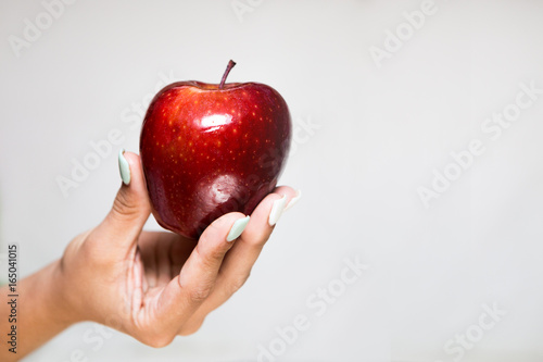 Female Hand Offering a Red Apple