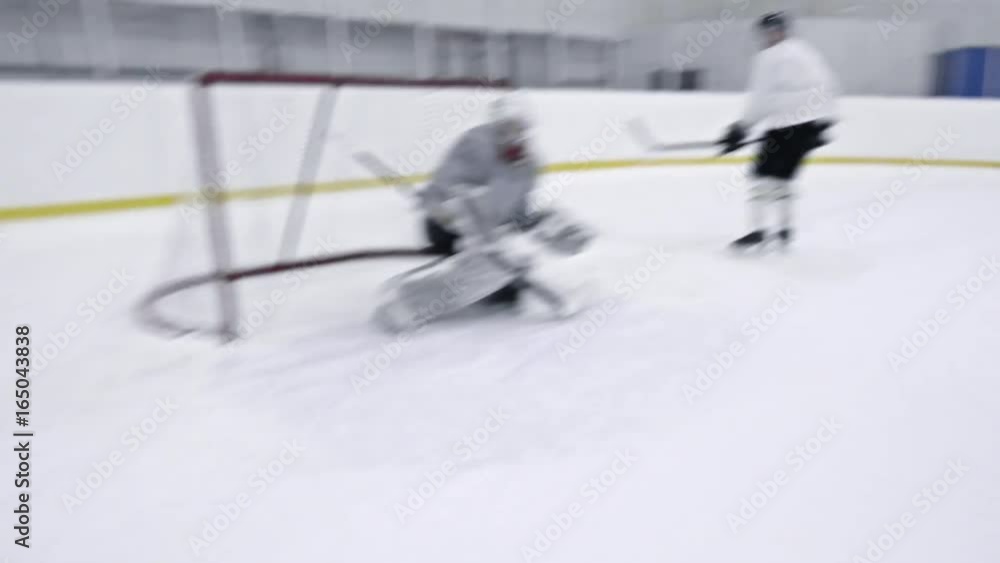 Tracking of ice hockey forward in white uniform dribbling puck past