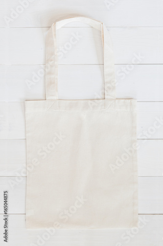 White tote bag mock up, fabric canvas cloth shopping sack template on wood table background