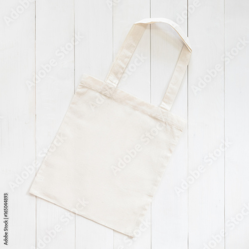 White tote bag mock up, fabric canvas cloth shopping sack template on wood table background photo