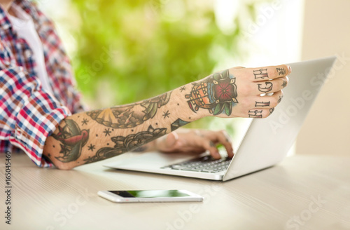 Young man with tattoo using...