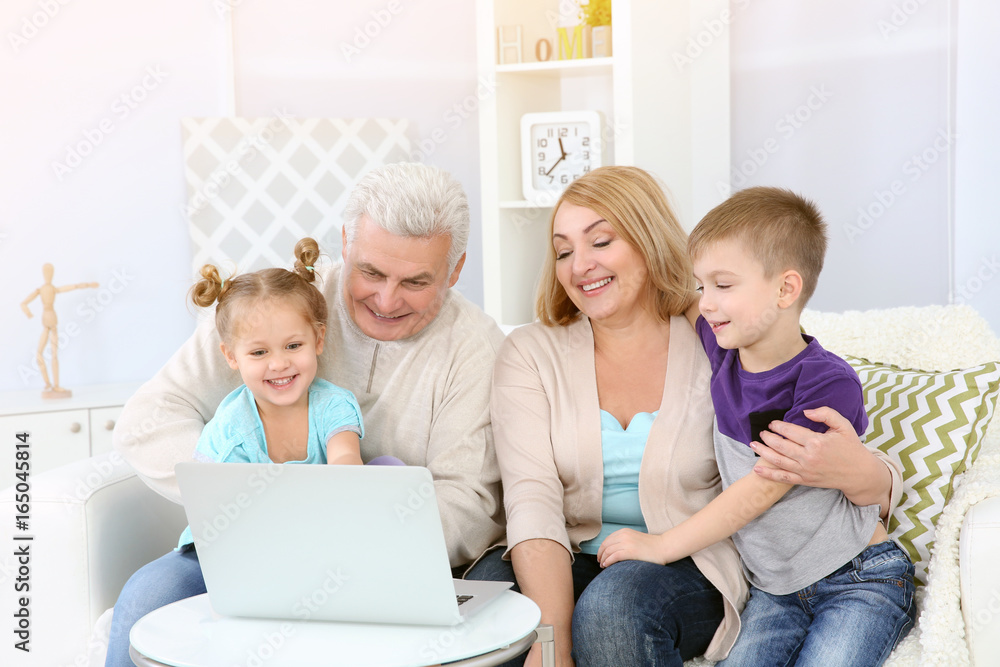 Children and grandparents using laptop at home Children and grandparents using laptop at home