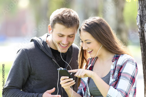 Two friends listening music and selecting song photo