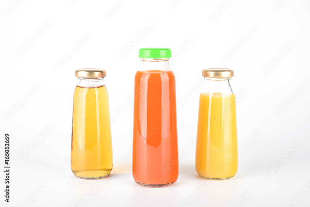 Apple, orange and carrot juice in bottles. Fruit and vegetable soft drink in a glass bottles isolated on white background Apple, orange and carrot juice in bottles. Fruit and vegetable soft drink in a glass bottles isolated on white background