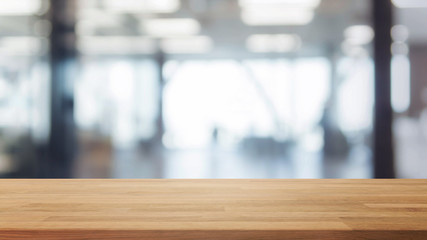 Wood table top and blurred bokeh office interior space background - can used for display or montage your products.