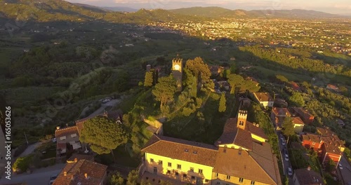 Aerial shot, a little ancient tuscan town on the hill in the sunset light in Italy, 4K photo