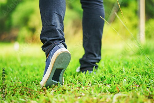 sneaker jeans walking on green grass 