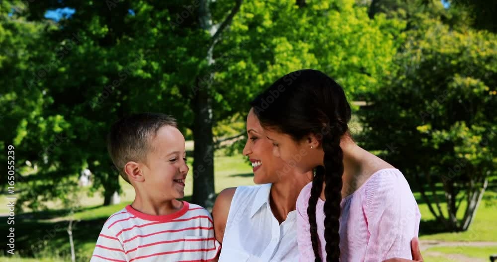 Mother interacting with her son and daughter in park Mother interacting with her son and daughter in park