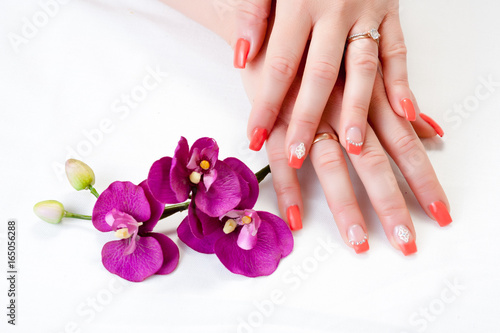 Obraz na płótnie female hands with orchid petals and nail art w salonie