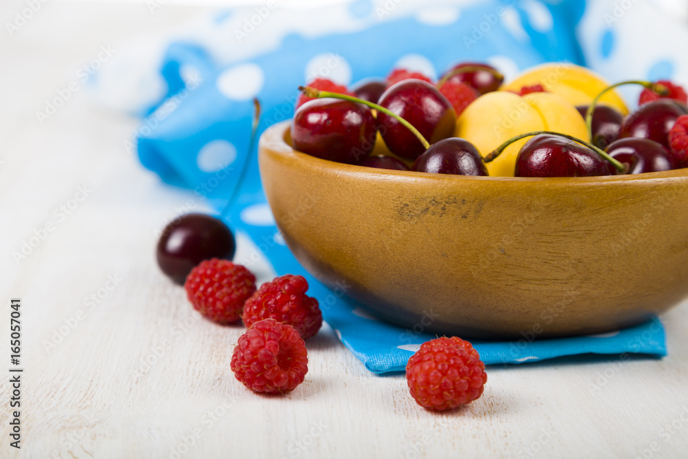 Ripe berries in a plate on a wooden table. Ripe berries in a plate on a wooden table.