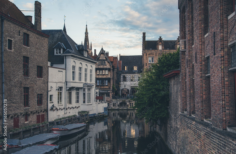 Evening view of typical canal of medieval city of Brugge with traditional houses