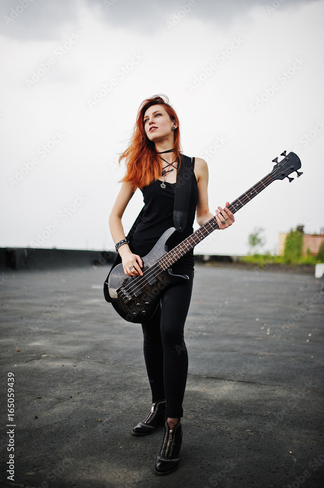 Red haired punk girl wear on black with bass guitar at the roof. Stock-Foto  | Adobe Stock