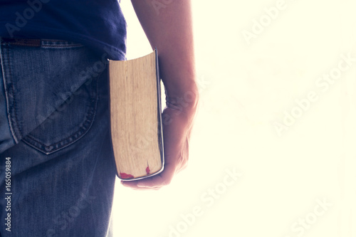 Man hand holding a bible isolated. Vintage color. This has clipping path.