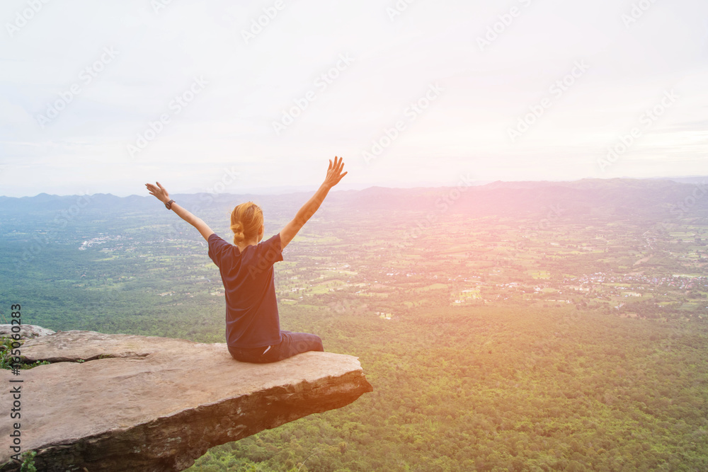 a woman sitting on cliff at Pha Hum Hod, Sai Thong National Park, Chaiyaphum Province, Thailand. a woman sitting on cliff at Pha Hum Hod, Sai Thong National Park, Chaiyaphum Province, Thailand.