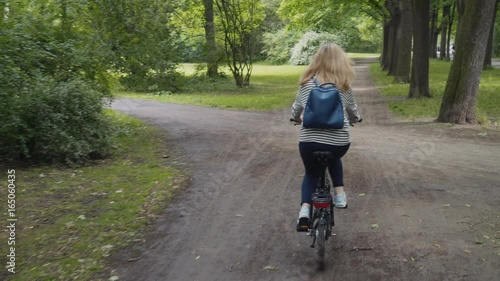 Wallpaper Mural young beautiful woman riding a black folding bicycle in a park Torontodigital.ca
