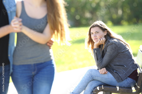 Fotografie Envious girl looking at a couple walking