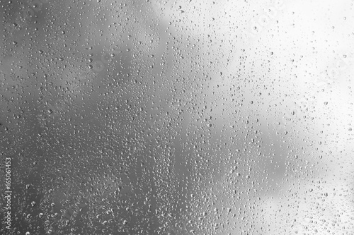 Horizontal black and white window glass with water drops background