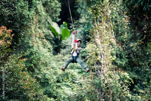 Woman going on a jungle zip line adventure, asia